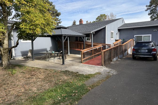 A covered patio and a wooden ramp up to the door.